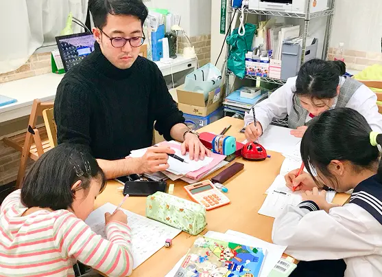 塾講師が生徒に寄り添って指導している様子の写真